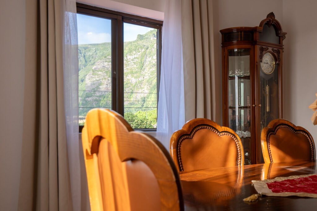 Spacious dining area at Casa da Sogra in Fajã Grande with panoramic ocean and mountain views, comfortable seating, and dining table for family gatherings